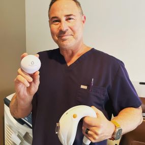 Dr. Austin holding eye care equipment to provide the best eye care services