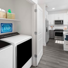 Desert modern style laundry room with full size washer and dryer alongside kitchen