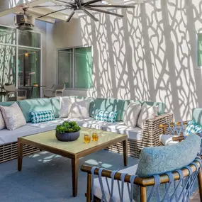 Trellised outdoor resident lounge with seating areas and misters and ceiling fan