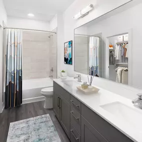 Desert modern style bathroom with double vanity sinks walk in closet and bathtub with tile surround