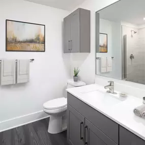 Desert modern style bathroom with white quartz countertop glass enclosed walk in shower and linen cupboards