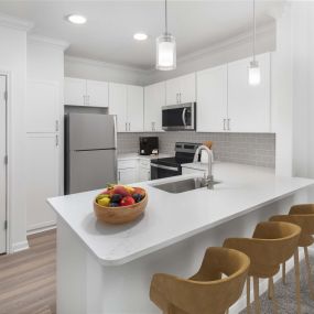 Camden Grand Harbor Apartments in Katy, TX, with white cabinets, white quartz countertops, and gray subway tile backsplash