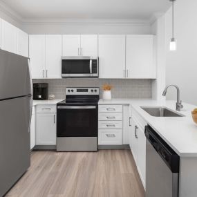 Camden Grand Harbor kitchen with white quartz countertops, stainless steel appliances and subway tile.