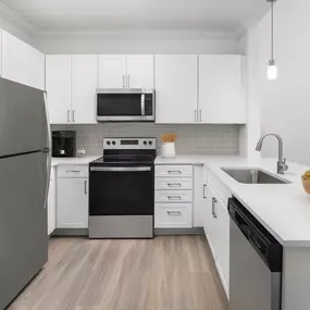 Camden Grand Harbor kitchen with white quartz countertops, stainless steel appliances and subway tile.