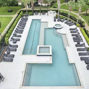 Resort style pool with lounge chairs at Camden Grand Harbor Apartments in Katy, Tx