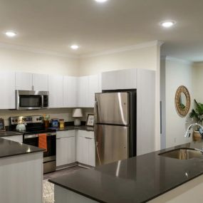 Entry level pricing on a kitchen remodel with white cabinets and black countertops.
