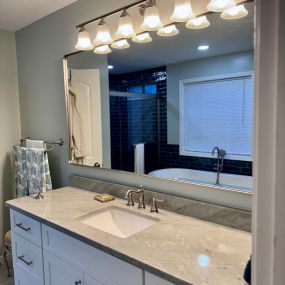 Full length wall mirror creates feeling of space in this master bathroom remodel.