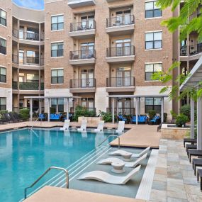 Resort-style pool with cabanas and in-water loungers at Camden Lamar Heights