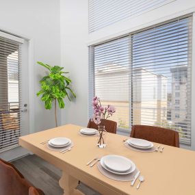 Camden Main and Jamboree Apartments Irvine CA modern open dining area near balcony under double height ceilings with wood-like flooring in kitchen