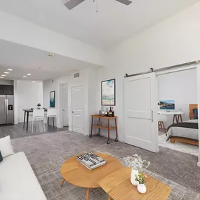 Open concept living room with barn door to bedroom