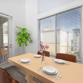 Camden Main and Jamboree Apartments Irvine CA modern open dining area near balcony under double height ceilings with wood-like flooring in kitchen