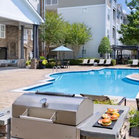 Pool with BBQ grills and dining tables at Camden Crest apartments in Raleigh, NC