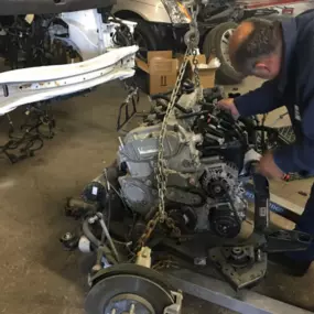 Precision engine removal and powertrain diagnostics underway at One Stop Collision Shop in Garden City, MI—highlighting our unmatched expertise in structural collision repair. This image showcases our ASE-certified technician carefully extracting a damaged engine assembly as part of a high-level restoration following a major front-end impact. Surrounded by advanced tools and late-model vehicles, this moment reflects our shop’s commitment to industry-leading craftsmanship, OEM-level accuracy, and
