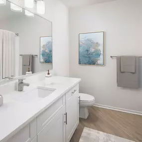 Bathroom with white quartz countertop and curved shower rod