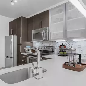 Kitchen with undermount sink, quartz countertop, and glass cooktop at Camden Gallery Apartments in Charlotte, NC