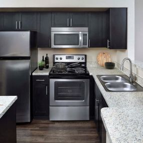 Expansive kitchen with stainless steel appliances including microwave