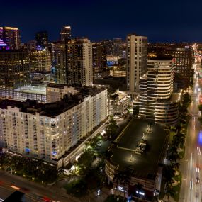 Exterior of Camden Las Olas apartments and E Broward Blvd in Fort Lauderdale, Florida at dusk.