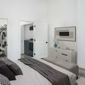 Bedroom with walk-in closet and Whirlpool washer and dryer in chrome shadow finish inside penthouse floor plans at Camden Las Olas in Fort Lauderdale, FL