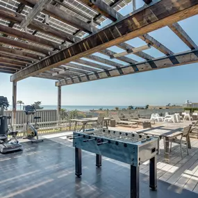 Outdoor lounge area with foosball and ping pong tables.