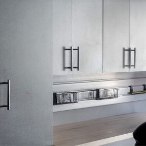 Modern and functional pewter colored garage cabinets. Featuring a butcher block workspace.