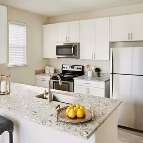 Kitchen with Stainless Steel Appliance, white cabinetry and quartz countertops