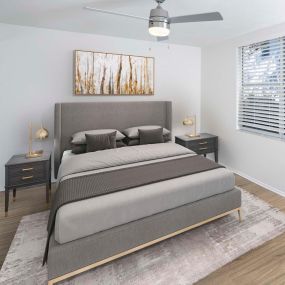 Beautifully renovated bedroom featuring ceiling fans with LED lighting, wood-look plank flooring throughout on first-floors, and neutral carpeting in second and third floor apartment homes.