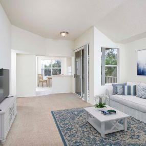 Living room with sliding glass door access to patio vaulted ceiling and carpet flooring