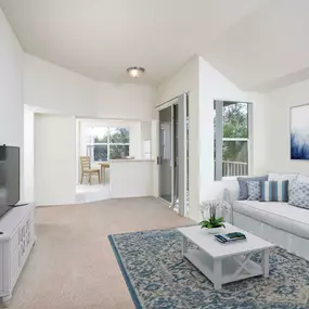 Living room with sliding glass door access to patio vaulted ceiling and carpet flooring