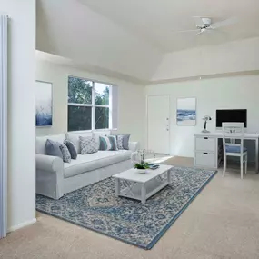 Living room with ceiling fan and work from home space alongside private patio