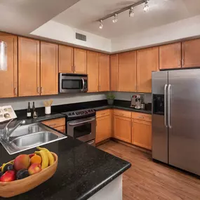 Kitchen with black granite countertops and stainless steel appliances