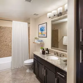 Bathroom with bathtub with tile surround and framed bathroom mirror