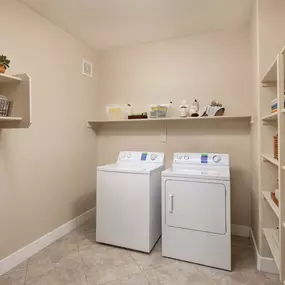 Full size washer and dryer in laundry room with shelving