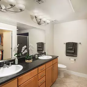 Bathroom with double sink vanity stand up shower and tile flooring