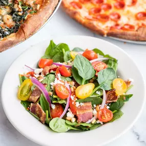 Spinach Salad with roasted red peppers, red onion, tomato, bacon, crumbled feta, toasted pine nuts. served with lemon basil vinaigrette.