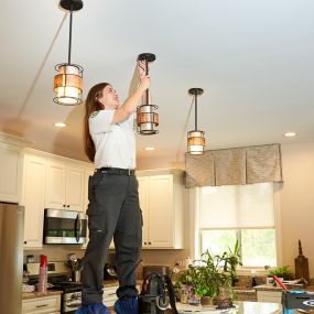 Mrs. Michael Electrician Working on light fixture inside home