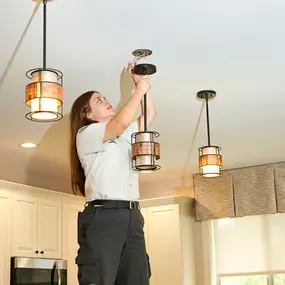 Mrs. Michael Electrician Working on light fixture inside home