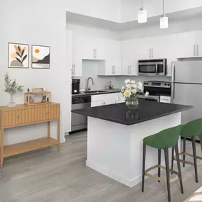 Kitchen in the white finish style with stainless steel appliances at Camden Thornton Park apartments in Orlando, FL