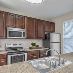 Kitchen with granite style countertops stainless steel appliances and tile backsplash