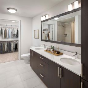 Bathroom with two sinks, walk-in closet, and soaking bathtub at Camden Rainey Street apartments in Austin, TX