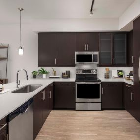 Kitchen with white quartz countertops and stainless steel appliances at Camden Rainey Street apartments in Austin, TX