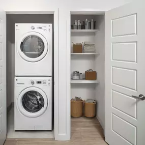 Closets with stacked washer and dryer and storage shelves at Camden Rainey Street apartments in Austin, TX