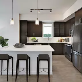 Kitchen with quartz countertops stainless steel appliances espresso cabinets and wood look flooring