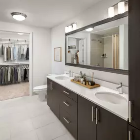 Bathroom with two sinks, walk-in closet, and soaking bathtub at Camden Rainey Street apartments in Austin, TX