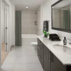 Bathroom with white quartz countertops and soaking bathtub at Camden Rainey Street