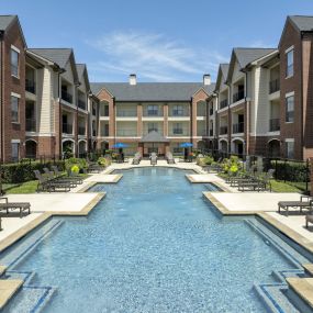 Pool 1 sundeck lined with lounge chairs at Camden Farmers Market apartments in Dallas, TX