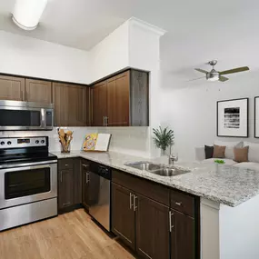 Contemporary-style kitchen and living room at Camden Farmers Market Apartments in Dallas, TX