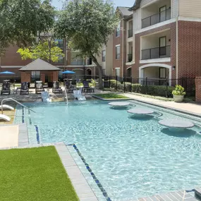 Pool 2 with in-water loungers and tables and a beach entry at Camden Farmers Market apartments in Dallas, TX