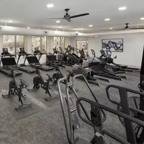 24-hour athletic club with cardio machines, Peloton bikes, rowing machines, and stair stepper at Camden Farmers Market apartments in Dallas, Tx