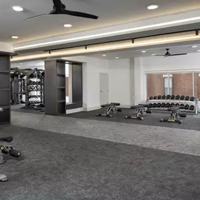 24-hour athletic club with free weights and multiple benches at Camden Farmers Market apartments in Dallas, Tx
