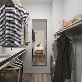 Large walk-in closet with wood-style flooring and wooden shelves and hanger rods